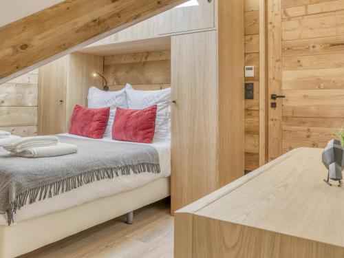 une chambre avec un lit avec des oreillers rouges dans l'établissement Appartement moderne avec accès direct aux remontées mécaniques à Saint-Gervais-les-Bains - FR-1-663-19, à Saint-Gervais-les-Bains