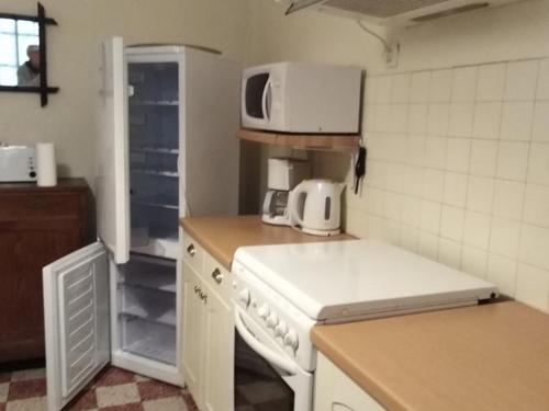 uma cozinha com um fogão branco e um micro-ondas em Appartement Vieux-Boucau-les-Bains, 4 pièces, 6 personnes - FR-1-379-158 em Vieux-Boucau-les-Bains
