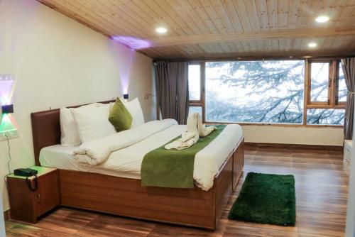 a bedroom with a large bed with a large window at Jakhu Vibes in Shimla