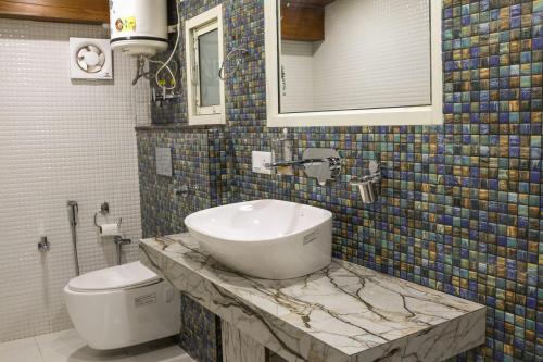 a bathroom with a sink and a toilet at Jakhu Vibes in Shimla