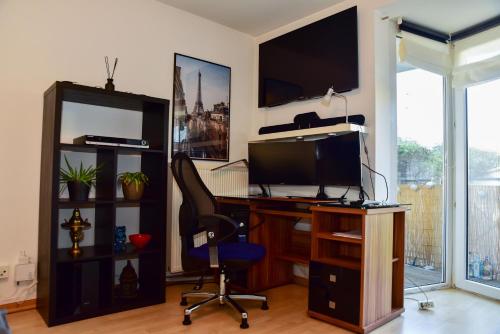 a room with a desk with a computer and a chair at Appartment mit großem Balkon im belgischen Viertel in Cologne