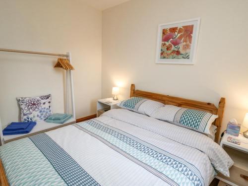 a bedroom with a bed and a table with a lamp at Llaethdy in Cardigan
