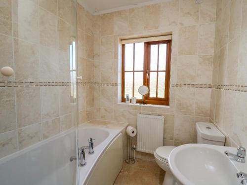 ein Badezimmer mit Badewanne, Toilette und Waschbecken in der Unterkunft Beudy in Cardigan
