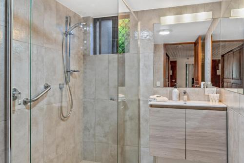 a bathroom with a shower and a sink at Fuller Holidays-Unit Pacific in Byron Bay