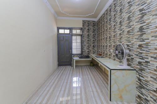 Zimmer mit Ziegelwand und Schreibtisch mit Ventilator in der Unterkunft RedDoorz Plus @ Villa Bontes Batu in Batu