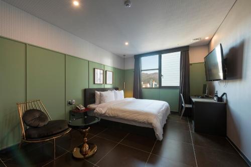 a bedroom with a bed and a desk and a television at Browndot hotel Guseo in Busan