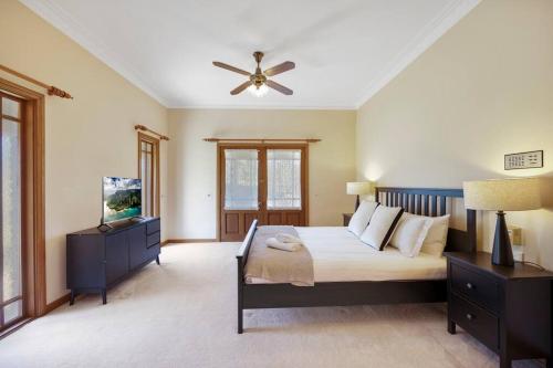 a bedroom with a bed and a ceiling fan at The Fletcher Estate in Nulkaba