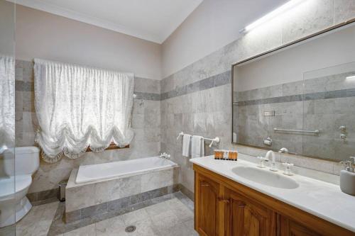 y baño con bañera, lavabo y espejo. en The Fletcher Estate en Nulkaba