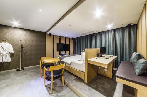 Habitación de hotel con cama, mesa y escritorio. en Jbis Hotel, en Uijeongbu