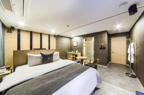 Jbis Hotel في Uijeongbu: غرفة نوم بها سرير كبير ومكتب