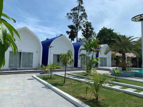 a villa with a blue roof and a swimming pool at Kampheak Roath Bungalows in Kampot