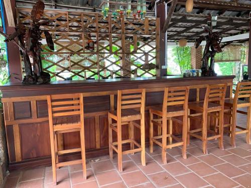 a bar with wooden stools and a counter top at Kampheak Roath Bungalows in Kampot