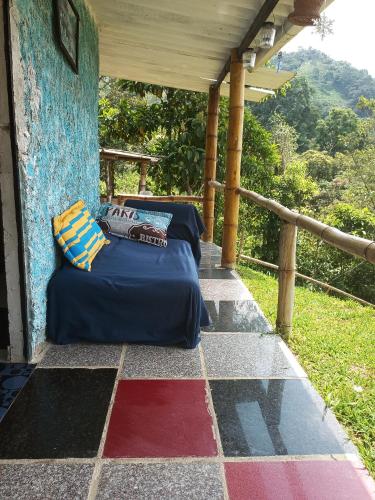 a bed on the porch of a house at Cabaña en el Campo in La Vega