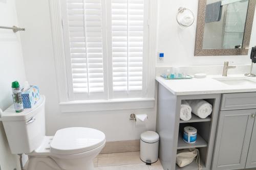 a white bathroom with a toilet and a sink at Tyler Inn at Zion in Rockville
