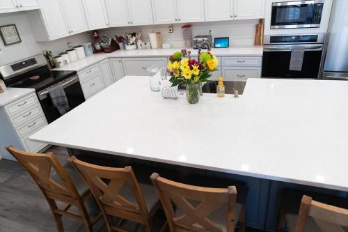 a kitchen with a white counter with a vase of flowers at Tyler Inn at Zion in Rockville