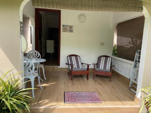 two chairs and a table in a living room at Orchid Sunset Guest House in Baie Lazare Mahé