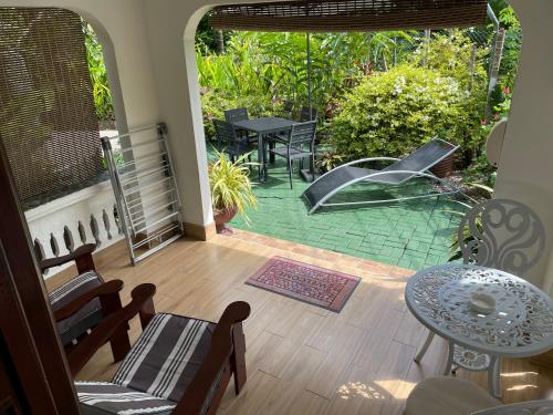 uma vista para um alpendre com um pátio com um baloiço em Orchid Sunset Guest House em Baie Lazare Mahé