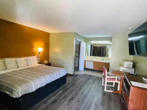 Pulaski的住宿－Budget Inn Pulaski，酒店客房设有一张床铺、一张桌子和一间厨房。