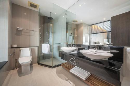 a bathroom with two sinks and a shower and a toilet at Ocean Portofino/Luxury2BR/153SQM in Na Jomtien