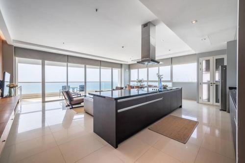 eine Küche mit einer Insel in einem großen Zimmer mit Meerblick in der Unterkunft Ocean Portofino/Luxury2BR/153SQM in Na Jomtien