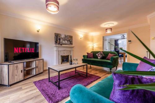 a living room with a tv and a couch and a table at Spacious house in quiet cul-de-sac near to Hospital in Shrewsbury