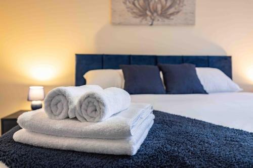 a room with a bed with towels on top of it at Spacious house in quiet cul-de-sac near to Hospital in Shrewsbury