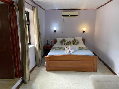 a small bedroom with a bed in a room at Orchid Sunset Guest House in Baie Lazare Mahé