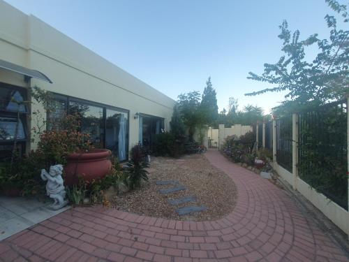 una pasarela de ladrillo frente a un edificio con jardín en DOTJJ B & B, en Paarl