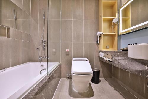 La salle de bains est pourvue de toilettes et d'une baignoire. dans l'établissement Hotel Midcity Myeongdong, à Séoul