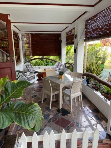 a patio with a table and chairs on a porch at Orchid Sunset Guest House in Baie Lazare Mahé