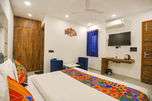 1 dormitorio con 1 cama y TV en la pared en FabExpress F9 Noida Sector 27 en Noida