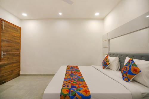 a bedroom with a bed with a colorful blanket on it at FabExpress F9 Noida Sector 27 in Noida