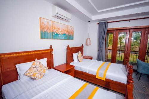 Ένα ή περισσότερα κρεβάτια σε δωμάτιο στο Ganesha Kampot Resort