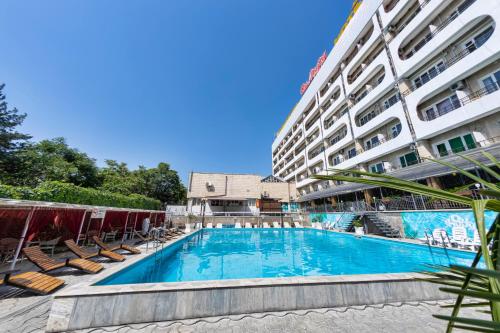 a swimming pool in front of a building at Hotel Osh-Nuru in Osh
