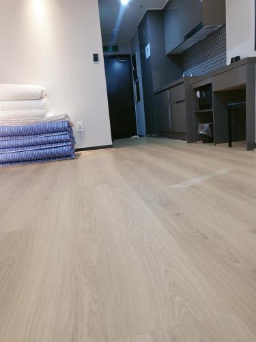 a room with a wooden floor and a pile of towels at Griffinbay Hotel in Busan