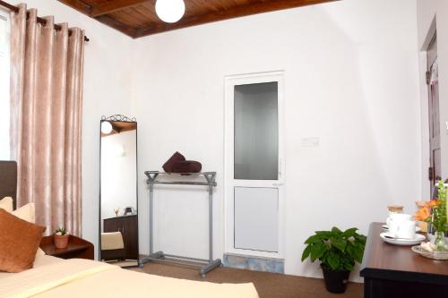 a bedroom with a bed and a mirror and a door at The Fern Inn in Nuwara Eliya