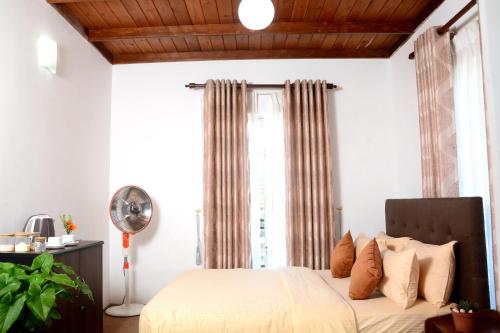 a bedroom with a bed and a window at The Fern Inn in Nuwara Eliya