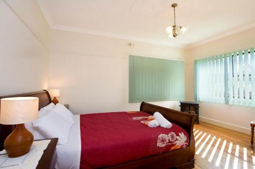1 dormitorio con 1 cama con colcha roja en Bella Vista en Apollo Bay