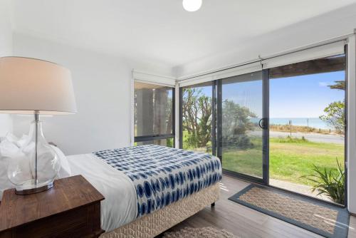 a bedroom with a bed and a large window at Blue Sea in Apollo Bay