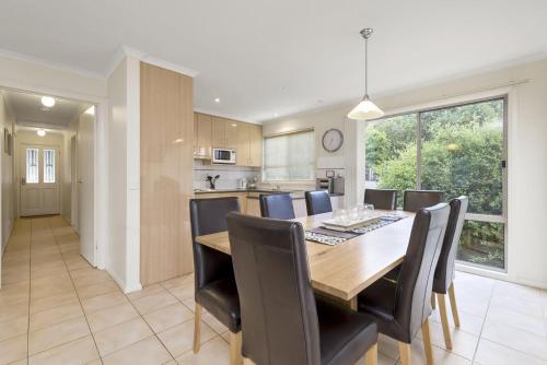 a kitchen and dining room with a wooden table and chairs at The Boulevard in Lorne