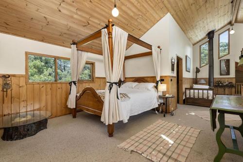 a bedroom with a canopy bed in a room with wooden walls at Walshan House in Apollo Bay