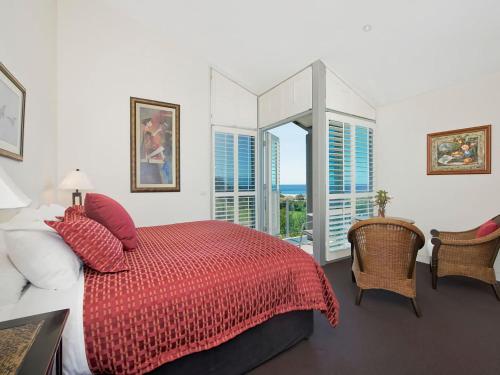 a bedroom with a red bed with a view of the ocean at Louvres in Wye River