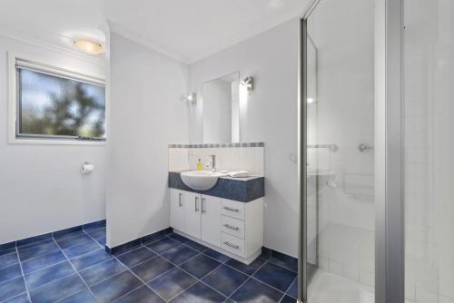 uma casa de banho com um lavatório e um chuveiro em Poseidon em Apollo Bay