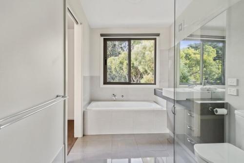 a white bathroom with a tub and a sink at Amaroo in Marengo