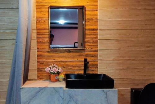 a bathroom with a black sink and a mirror at RedDoorz @ Dolce Cabanas Beach Resort in Zambales