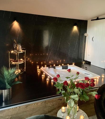 a room with a bath tub with candles and roses at Kudos Villas - Hepburn Springs in Hepburn Springs