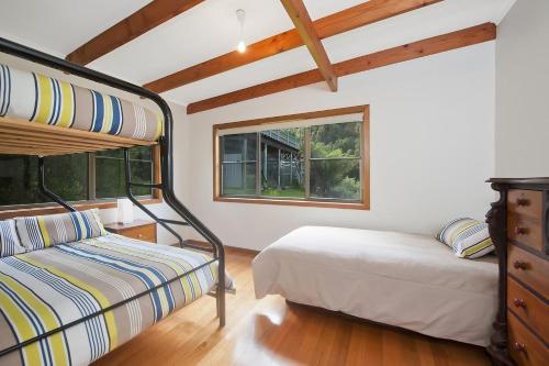 a bedroom with two bunk beds and a window at At Riverside in Wye River