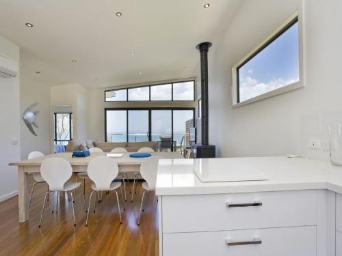 a kitchen and dining room with a table and chairs at Earth Sea Sky in Wye River