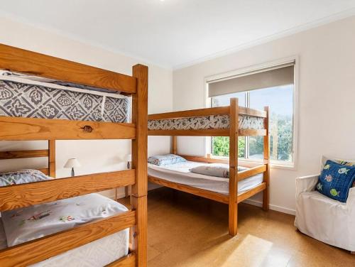 a bedroom with two bunk beds and a window at Bimbadeen in Apollo Bay