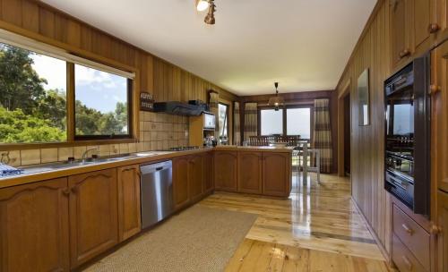 cocina grande con paredes de madera y armarios de madera en 2 Degrees of Separation, en Wye River